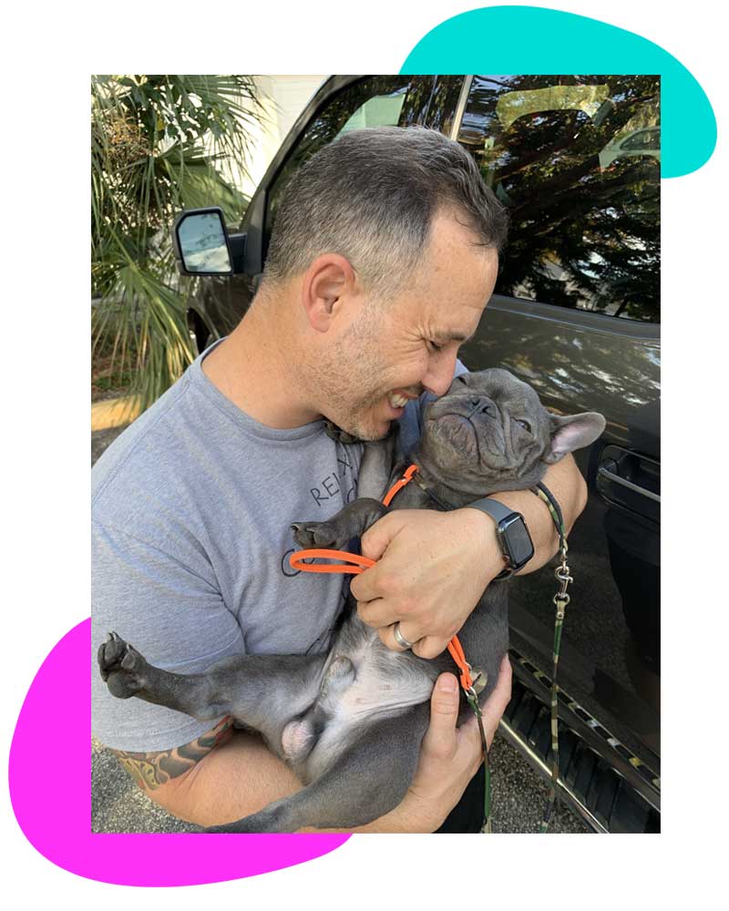 Alex Alvarez, founder of iDog Academy, holding a French Bulldog